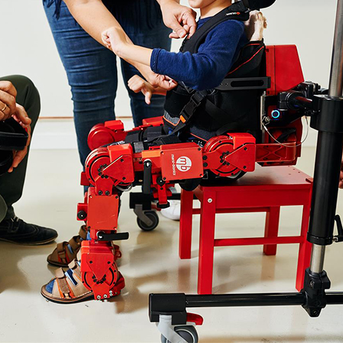 Child wearing ATLAS 2030 exoskeleton in seated position